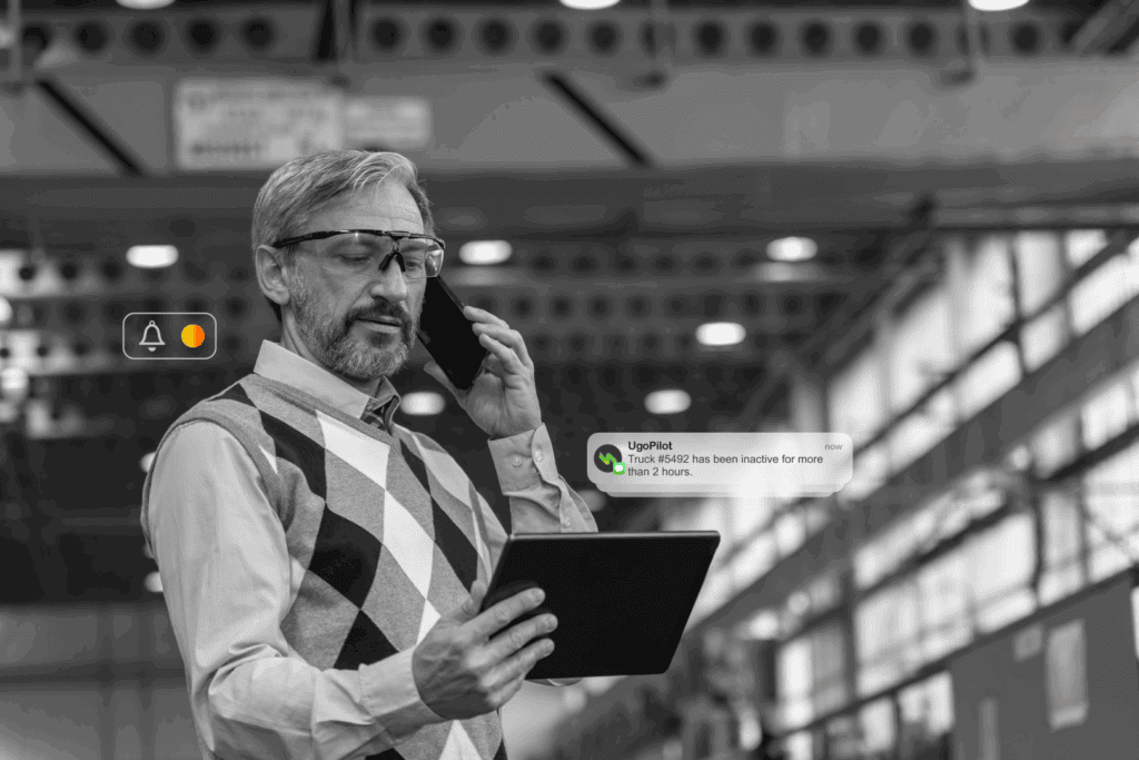 Manager receives UgoPilot alert on tablet about truck inactivity, illustrating smart fleet monitoring.
