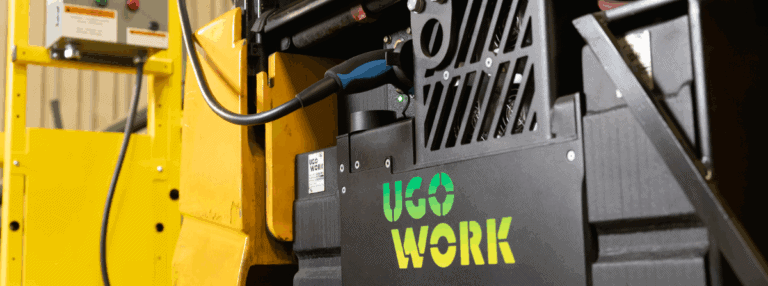 Close-up of a UgoWork lithium-ion battery charging while mounted in a yellow forklift, highlighting onboard charging capability.