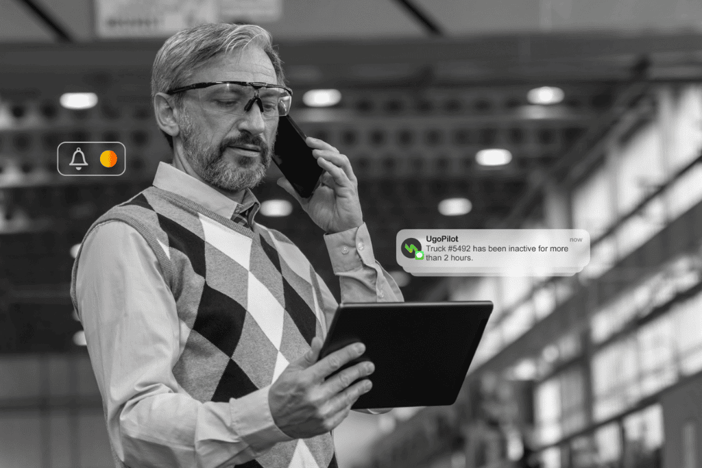 UgoWork travailleur à distance utilisant tablette et téléphone avec notifications de gestion de drones, technologie d'espace de travail moderne, connectivité IoT.