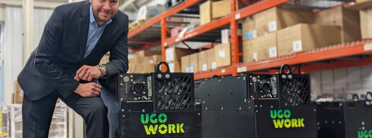 Businessman leaning on a lithium-ion battery for industrial trucks