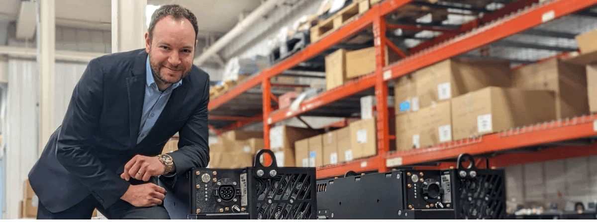 Businessman leaning on a lithium-ion battery for industrial trucks