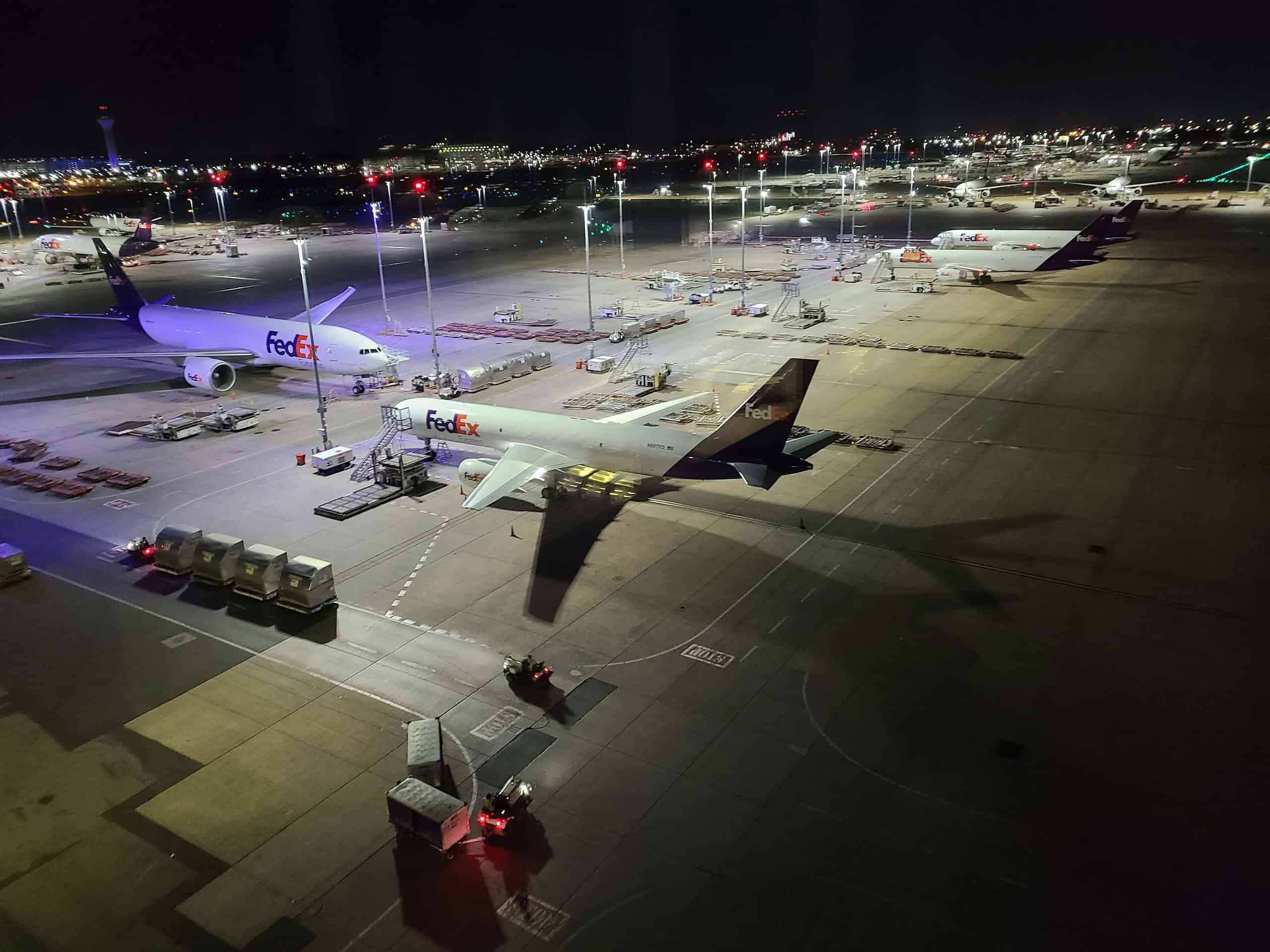 FedEx aircraft lined up on the tarmac at night.