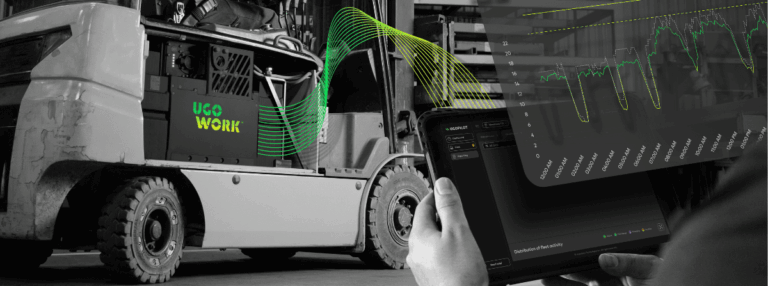 Opérateur manœuvrant un chariot élévateur équipé d'une batterie UgoWork, tandis qu'une autre personne surveille les données énergétiques sur une tablette avec le logiciel UgoPilot.