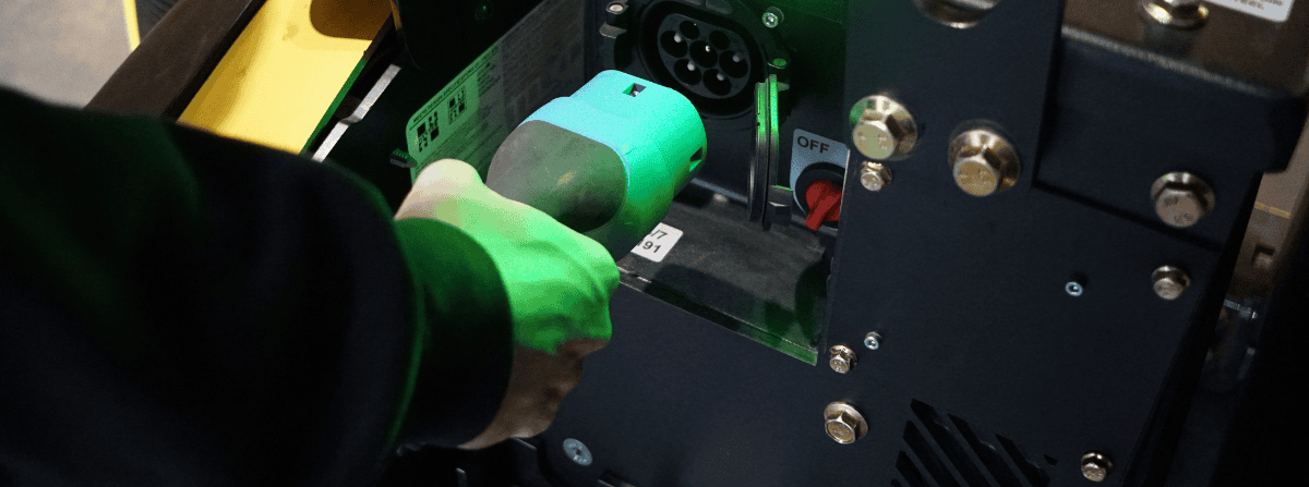 Une main en train de brancher le connecteur de recharge dans la batterie UgoWork.