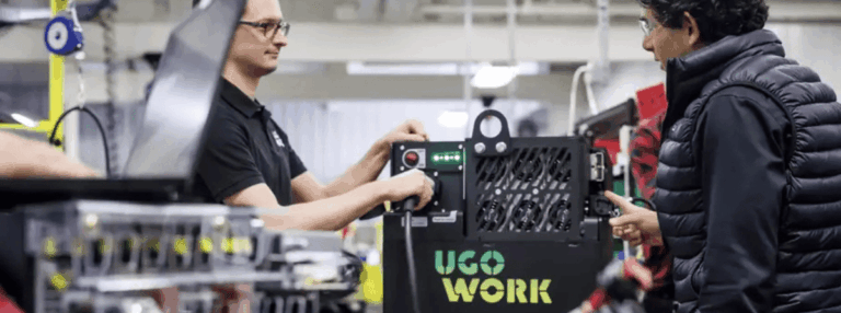 Deux hommes discutent dans une usine, avec des câbles électriques au premier plan