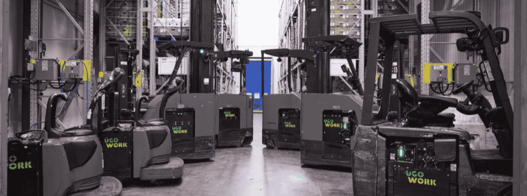 Material handling equipment equipped with UgoWork batteries, neatly aligned in a refrigerated warehouse.