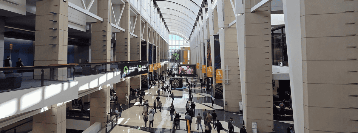 Interior view of a busy trade show venue at McCormick Place during ProMat 2025, with attendees walking through the main exhibition hall.