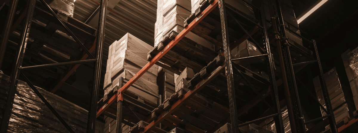 Warehouse aisle with shelves and stacked boxes.