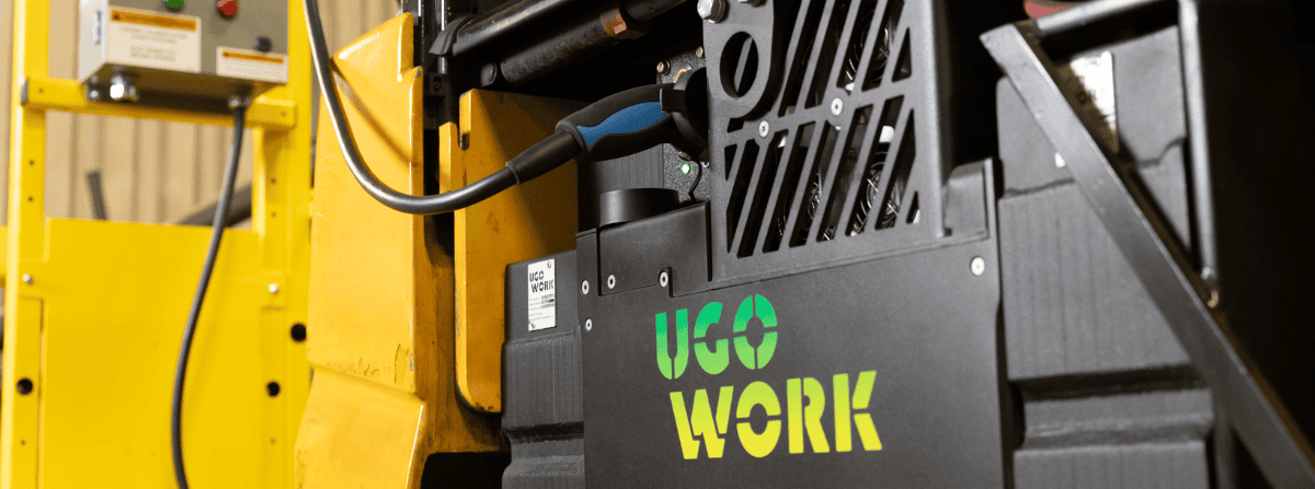 Gros plan d’une batterie lithium-ion UgoWork en recharge dans un chariot élévateur jaune, illustrant la recharge embarquée.
