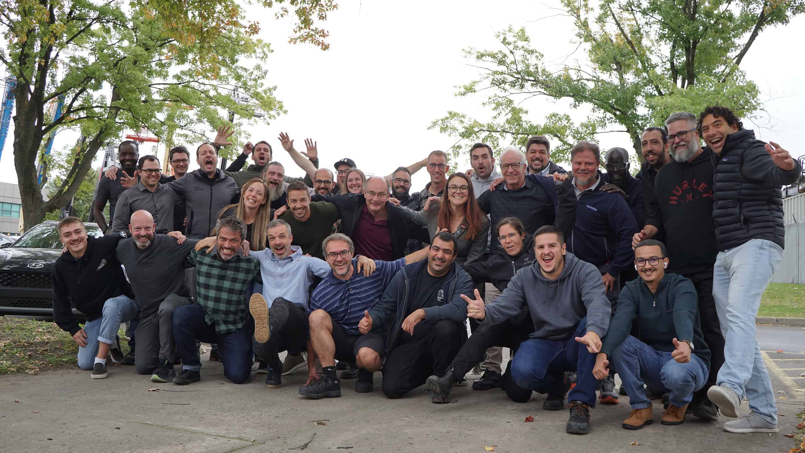 Une photo de groupe de l'équipe d'UgoWork, tous souriants avec des expressions festives, réunis pour un moment de célébration.