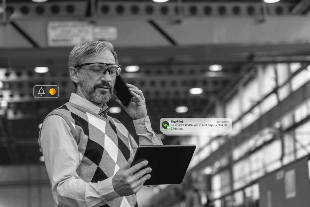 Gestionnaire recevant une alerte UgoPilot sur tablette concernant l'inactivité d’un chariot, illustrant le suivi intelligent de flotte.