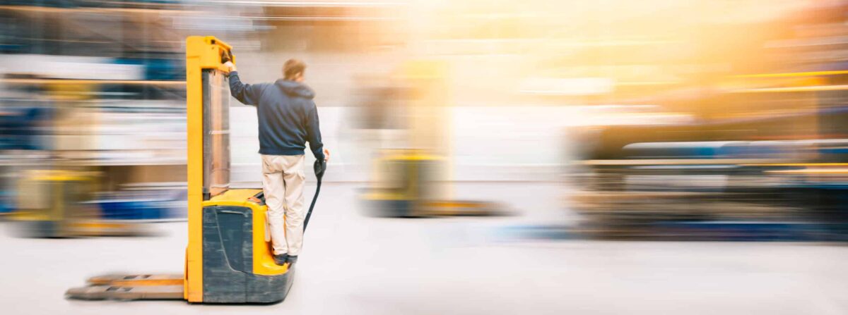Forklift Worker In Motion at Work in Warehouse