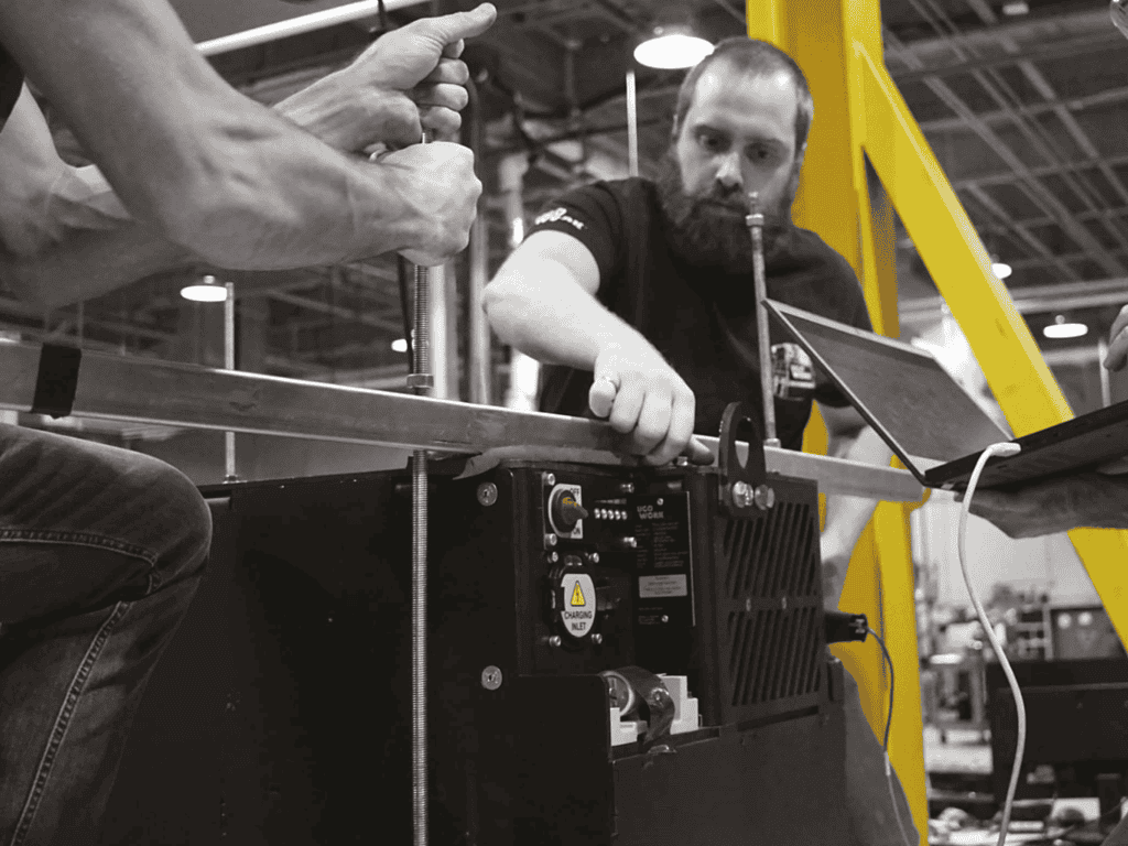 Engineers assembling and testing a UgoWork lithium-ion battery in a manufacturing facility.